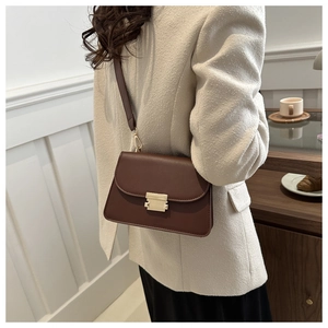 Lifestyle view of a vintage brown leather crossbody bag with golden square lock clasp