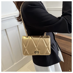 Detail shot of the golden quilted chain bag showing metallic leather and hardware lock