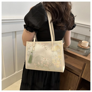 Close-up of floral silk tote bag with green tassel and traditional Chinese pattern
