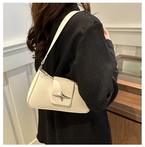 Detailed side view of white PU leather underarm bag with silver star buckle on model