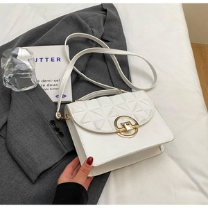Detailed macro view of white quilted faux leather bag with geometric gold ring buckle hardware