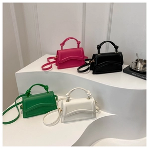 Detailed view of structured square bags in pink, black, green, and white with knotted handles