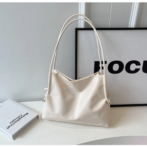 Dettaglio della borsa tote in pelle crema con eleganti nodi decorativi laterali