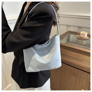 Close-up of light blue nylon hobo bag with onwards and upwards letter embroidery detail
