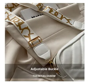 Close-up of white quilted crossbody bag with adjustable wide pattern canvas strap