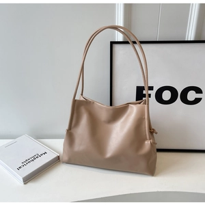 Dettaglio della tote bag beige minimalista con nodo a coulisse e spalline sottili