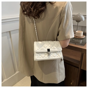 Detailed back view of a white quilted chain shoulder bag worn on a minimalist outfit