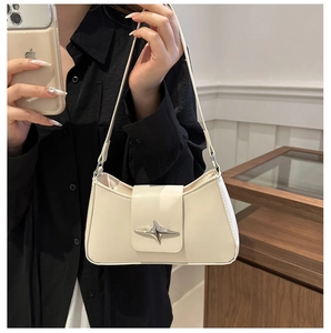 Detail of off-white faux leather shoulder bag with a silver cross-star metal buckle close-up