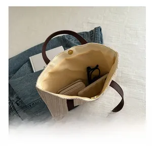 Macro view of woven tote bag interior showing magnetic closure and large storage capacity