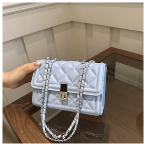 Close-up of light blue quilted crossbody bag with silver chain and metal lock