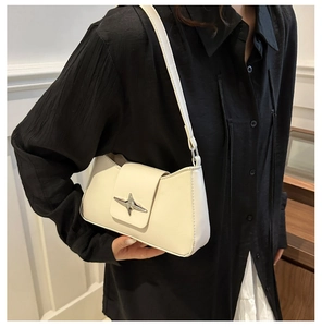 Detail of off-white shoulder bag featuring a silver star-shaped metallic buckle and PU leather