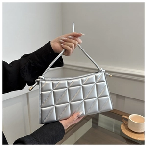 Detailed close-up of a metallic silver quilted crossbody bag with triangular stitching detail