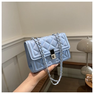 Detail of light blue quilted leather bag featuring silver chain strap and twist lock