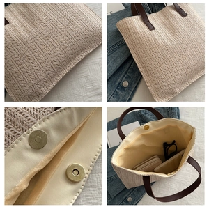 Detail view of woven straw tote bag with leather handles and gold magnetic closure
