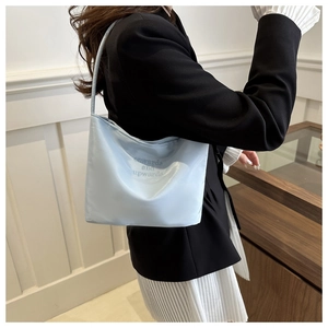 Close-up of light blue satin tote bag with onwards and upwards letter embroidery detail