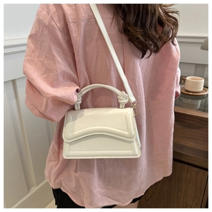 White minimalist crossbody bag with wavy stitching and knotted handle shown on model