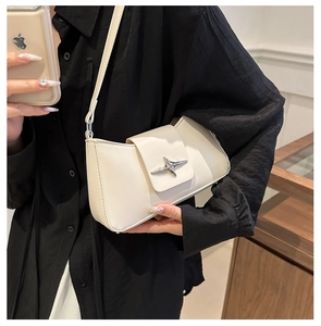 Detail of cream white underarm bag with silver star buckle and smooth PU texture