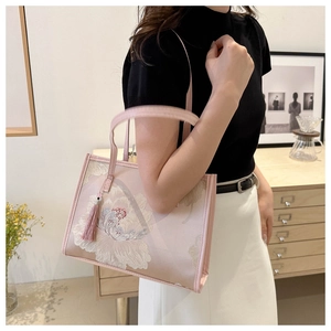 Detail of pink satin tote bag with exquisite peony embroidery and decorative tassel