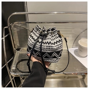 Detail of black and white geometric ethnic pattern on bucket bag with drawstring closure