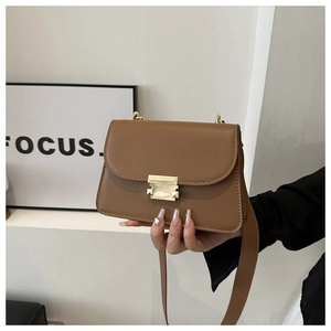 Close-up of caramel square crossbody bag with gold lock buckle and wide strap