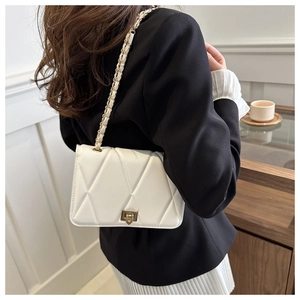 Close-up of white quilted chain bag showing the elegant diamond stitching and metal lock