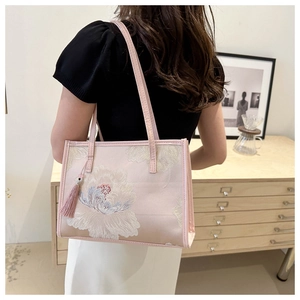 Détail du sac cabas rose avec broderie florale exquise et pompon assorti