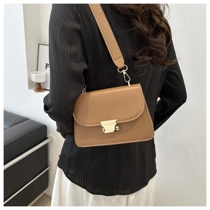 Detail view of the smooth camel leather shoulder bag with gold square lock and wide strap
