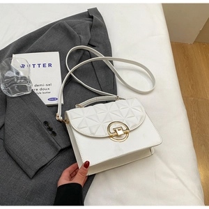 Top view of white box-shaped crossbody bag with quilted lid and gold metal buckle