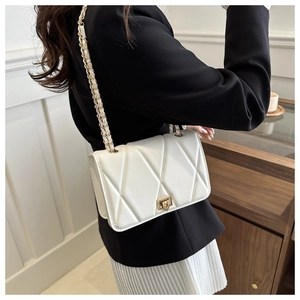 Detail of white quilted crossbody bag with golden chain strap and swivel lock