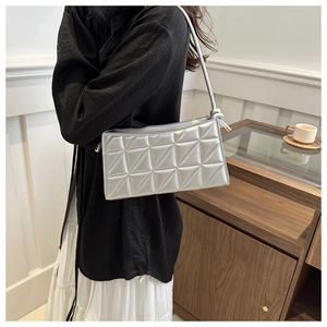 Silver rectangular underarm bag with geometric quilting and metallic finish on shoulder