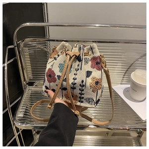 Close-up of vintage floral embroidery and drawstring closure on ethnic style bucket bag