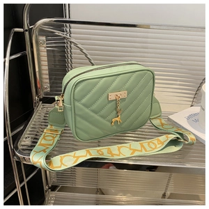Detail of light green crossbody bag featuring V-quilt pattern and Lucky wide strap
