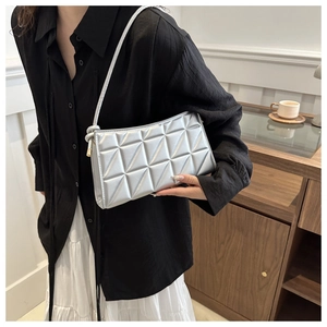 Detail of silver geometric quilted shoulder bag with metallic texture and gold zipper accents