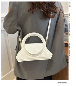 Borsa a tracolla geometrica bianca moderna su modella con blazer grigio e manico superiore