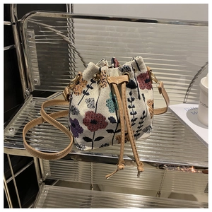 Close-up of jacquard fabric bucket bag featuring floral patterns and drawstring closure