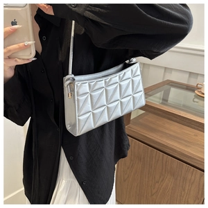Detail of silver quilted crossbody bag with metallic sheen and elegant stitching