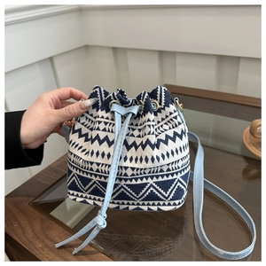 Detail of ethnic geometric pattern bucket bag with light blue drawstring and handle