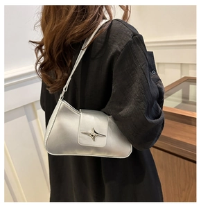 Detail view of silver underarm bag with star buckle and sleek PU leather texture