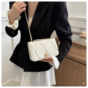 Close-up of white quilted leather crossbody bag with gold chain and metal clasp