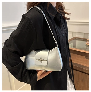 Close-up of metallic silver baguette bag featuring a stylish star-shaped metal buckle