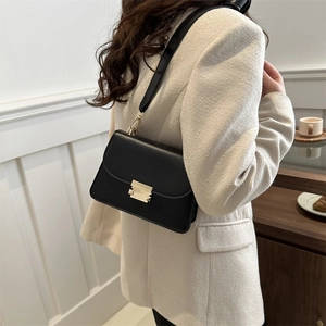 Minimalist black leather square crossbody bag with gold buckle and wide shoulder strap