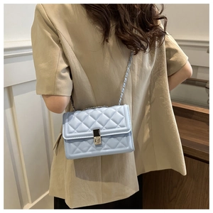 Vue détaillée du sac matelassé bleu clair avec bandoulière chaîne sur un mannequin