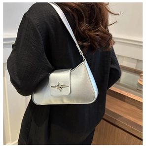Detailed view of silver metallic shoulder bag with a designer star-shaped buckle