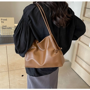 Brown faux leather tote bag featuring unique knot detail on shoulder strap for women
