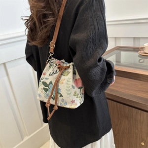 Ethnic style floral embroidery drawstring bucket bag with leather strap worn on shoulder
