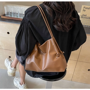Detail of soft caramel faux leather tote bag with elegant side knot and double straps