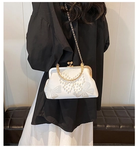 Détail du sac vintage en soie blanche avec perles, motifs papillons et chaîne dorée