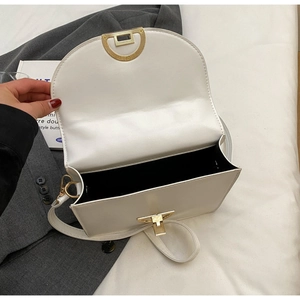 Detailed interior of a white semi-circular leather bag with golden metallic hardware