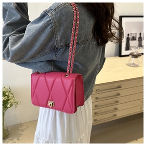 Detail of pink quilted crossbody bag with golden chain strap and twist lock closure