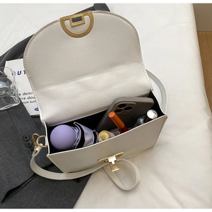 Close-up of a white leather crossbody bag interior showing phone and umbrella storage